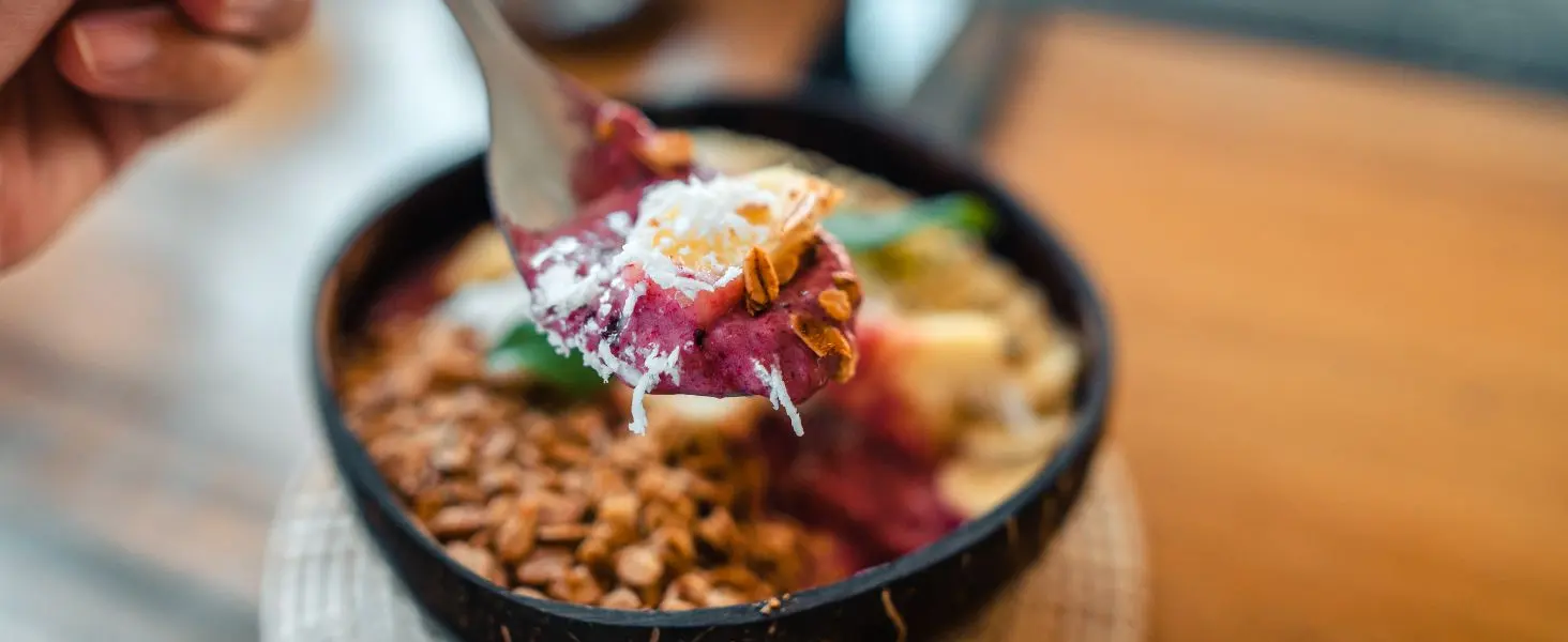 coconut bowl smoothie with granola coconut flakes and fruit healthy breakfast in eco-friendly coconut shell bowl