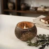 Eco-friendly coconut shell candle holder styled with greenery, boho natural home decor aesthetic with sustainable materials